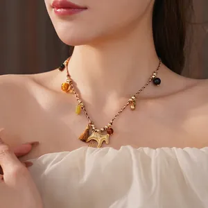 Vintage woven horse pendant necklace with gold beads and tassels worn by a model