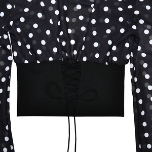 Detail view of the lace-up back design and white polka dot mesh on a black chiffon top