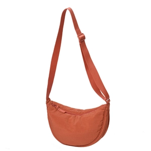 Minimalist orange crescent crossbody bag with adjustable strap and zipper closure