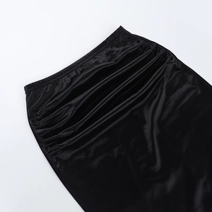 Dettaglio della gonna in raso nero con vita elastica e pieghe laterali eleganti
