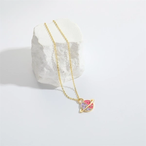 Chic gold Saturn pendant necklace with pink and purple enamel on a white stone base