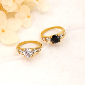 Elegant gold titanium rings set with black and white zircon stones on a floral background