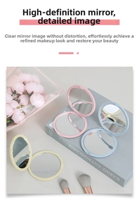Three compact foldable makeup mirrors in pink, light blue, and beige on a stylish setup