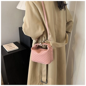 Pink woven stone texture crossbody bag with adjustable strap and metal hardware detail