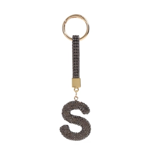 Macro shot of letter S keychain featuring dark grey rhinestones on a gold alloy frame