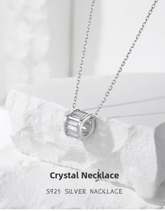 Macro detail of S925 silver cylinder necklace with baguette-cut crystals on stone
