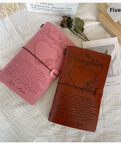 Custom leather travel notebooks in pink and brown with engraved hearts and message for daughter