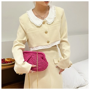Detail of a pink woven clutch bag paired with a beige tweed jacket and lace collar