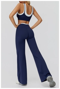 Detail view of navy blue and white yoga set featuring flared pants and cross-back sports bra