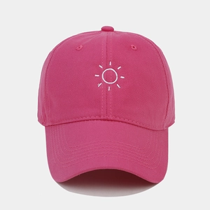 Detailed view of sun embroidery on a rose pink cotton twill baseball cap crown