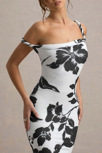 Detail of the off-shoulder neckline and black floral print on a slim white dress
