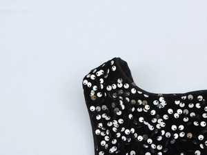 Close-up detail of silver sequins on black fabric of a slim fit backless party dress