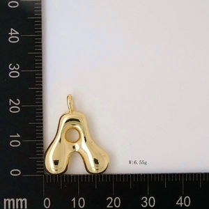 Detailed view of glossy gold balloon initial A pendant showing weight and size measurement
