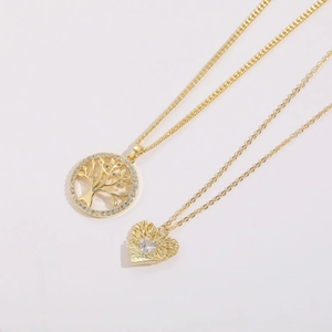 Detail shot of 14K gold plated Tree of Life and heart pendants with zircon stones