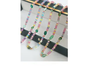 Détail d'un collier de perles colorées avec pierres d'agate verte et accents dorés