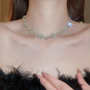 Nahaufnahme einer eleganten Silberhalskette mit runden Kristallen am Model in Schwarz