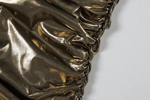 Détail du tissu doré métallisé avec des fronces élégantes et une brillance nacrée