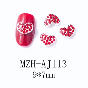 Macro detail of red heart nail charms with metal base and crystal, 9x7mm size