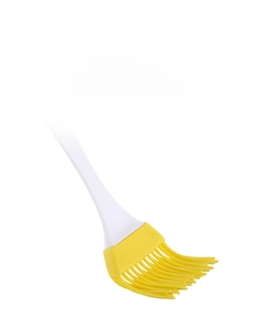 Detail view of yellow silicone oil brush with white handle for BBQ and baking