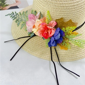 Women straw sun hat with floral decorations and black ribbons for summer beach beach
