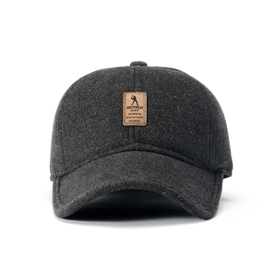Detail einer dunkelgrauen Wollmütze mit Lederaufnäher und Golfmotiv für Herren