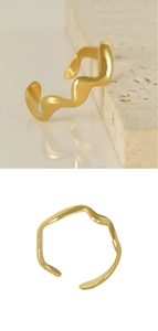 Detail of adjustable wavy 18K gold plated stainless steel ring on marble stone