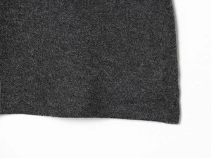 Gros plan sur la texture en maille gris foncé de ce haut sans manches à col en V