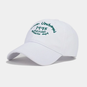 Detail of green athletic embroidery on a white cotton canvas baseball cap for women
