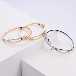 Three-piece butterfly bangles in rose gold, gold and silver set on white stone blocks