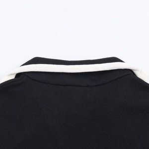 Detailansicht des schwarzen Strickkleidkragens mit weißen Kontraststreifen am Rand