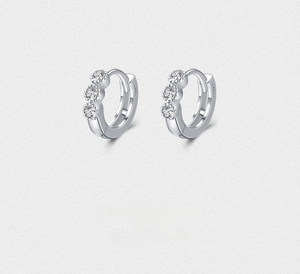Macro detail of S925 sterling silver hoop earrings with three small clear zircon stones
