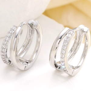 Macro shot of silver double-hoop earrings featuring pavé-set cubic zirconia and a latch closure