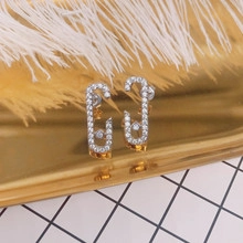 Close-up of silver-finish earrings with moving zircon stone on a stylish display