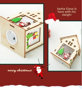 Detail of wooden Christmas house ornament with LED light, snowman and tree motifs