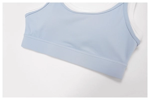 Detail of blue faux-layered sports bra with white ribbed texture and smooth fabric