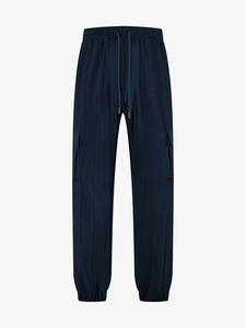 Detail of navy blue cargo pants featuring breathable textured fabric and drawstring waist