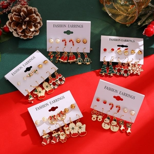 Detail of Christmas earring set with Santa, reindeer and snowflake designs on card