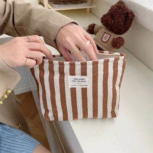 Detailed view of striped canvas storage bag with top zipper and woven fabric label
