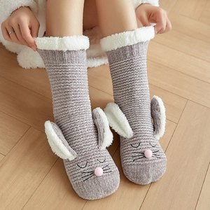 Winter fuzzy rabbit socks in grey with 3D ears on a light wood floor background