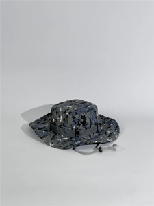 Detail view of the digital camouflage fabric texture and metal ventilation eyelets on the hat