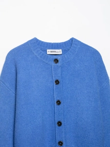 Close-up of the soft sky blue knitted cardigan texture with high-quality buttons