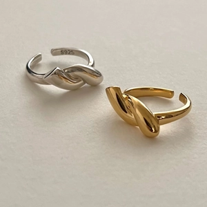 Macro shot of S925 sterling silver knotted open rings in gold and silver finishes