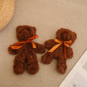Pair of brown plush teddy bears with orange satin bows on a soft white carpet background