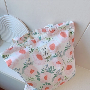 Gros plan d'un sac cabas en toile à motif floral rose avec étiquette tissée rétro