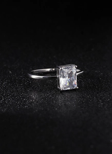 Macro shot of silver ring with emerald-cut clear cubic zirconia in four-prong setting