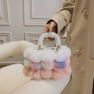 Detail of plush faux fur handbag with white crocodile pattern leather handle