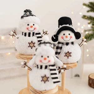 Three plush Christmas snowmen in black and white plaid decor on a wooden tiered stand