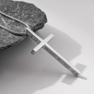 Gros plan du pendentif croix en acier inoxydable argenté avec gravure sur le côté