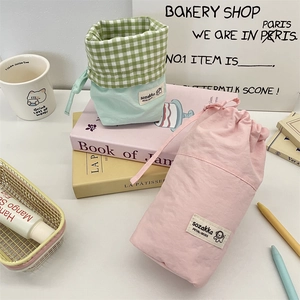 Detail of pink and mint green drawstring storage bags in cotton canvas material