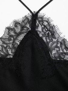 Gros plan détaillé sur la dentelle de cils et la texture satinée noire d'une robe licou